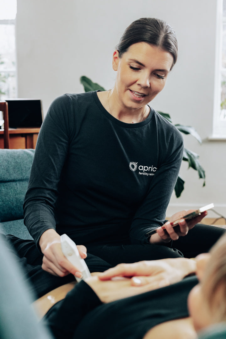 Woman carrying out an ultrasound during fertility treatment