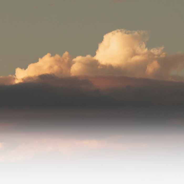 A cloud formation illuminated by sunlight against a gradient sky.
