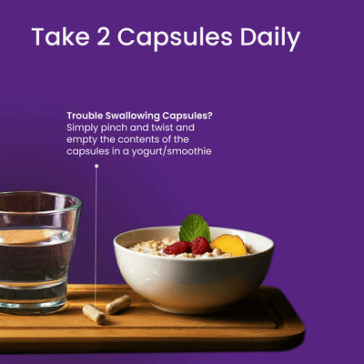 Bowl of cereal with fruit, glass of water, and capsules on a wooden tray with purple background