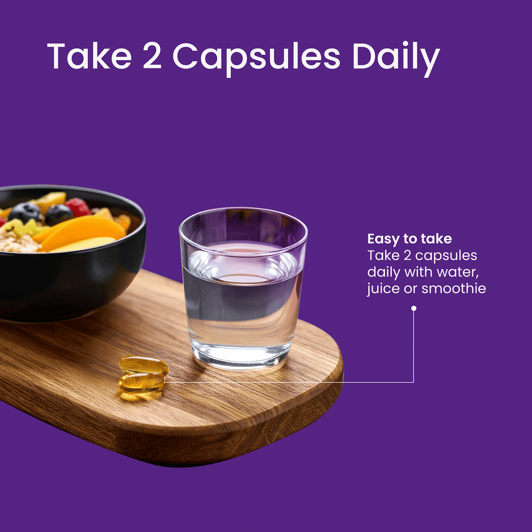 Glass of water, bowl of fruit, and capsules on a wooden board with purple background and text.