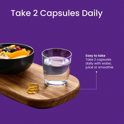 Glass of water, bowl of fruit, and capsules on a wooden board with purple background and text.