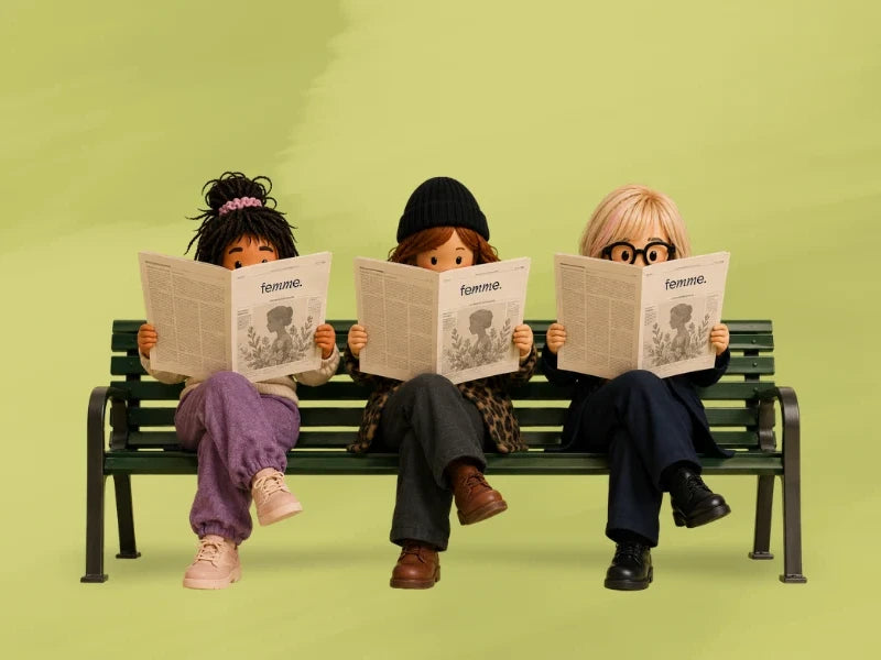 Three dolls sit on a bench reading copies of Femme magazine against a green background.