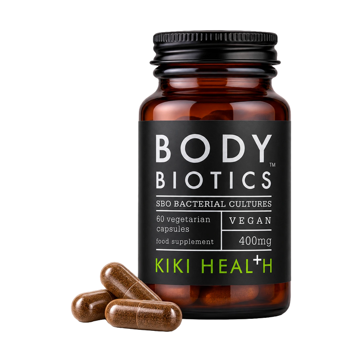 A bottle of Body Biotics Kiki Health SBO Bacterial Cultures vegan food supplement capsules, shown with three brown capsules in front of the amber glass bottle on a white background.