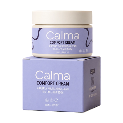 A jar of Calma Comfort Cream sits on top of its matching product box against a plain white background. The packaging features a lavender-purple label with white text and dark purple abstract line details, and a cream-colored lid and base.