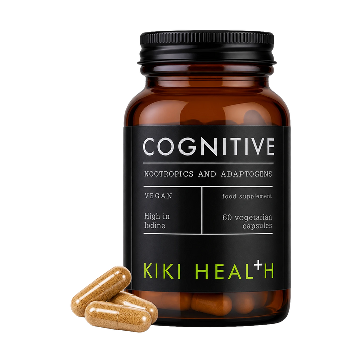An amber glass supplement bottle labeled 'COGNITIVE' by Kiki Health, with three tan capsules placed in front on a clean white background.
