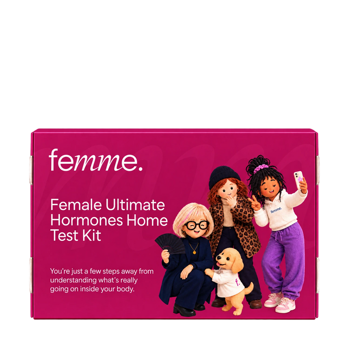 A bright pink rectangular product box for the femme Female Ultimate Hormones Home Test Kit, featuring white text and an illustration of four dolls and a small dog on the front.