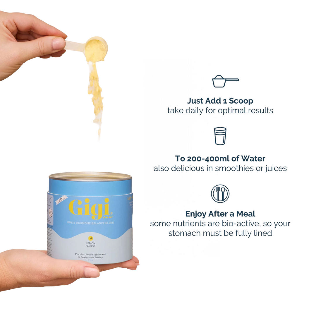 A hand holds a canister of Gigi Probiotic Balance Blend powder, with a scoop of the yellow powder being lifted above it. Text on the right explains how to use the product: add one scoop daily, mix with 200-400ml of water, and enjoy after a meal.