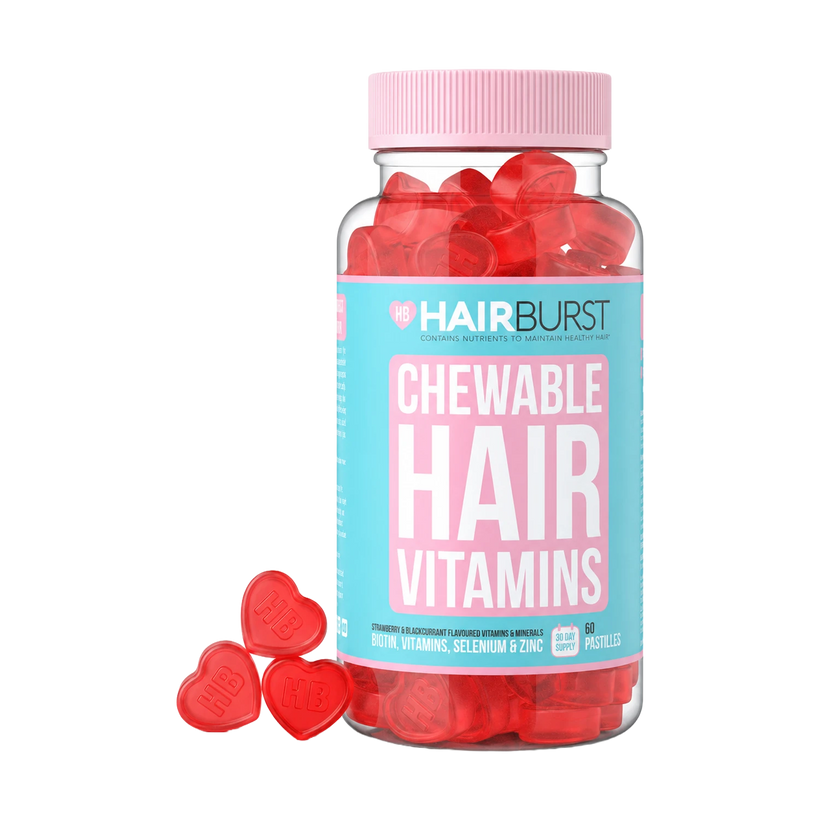 A bottle of HAIRBURST Chewable Hair Vitamins filled with red heart-shaped gummies, with three red heart gummies placed in front on a clean white background.
