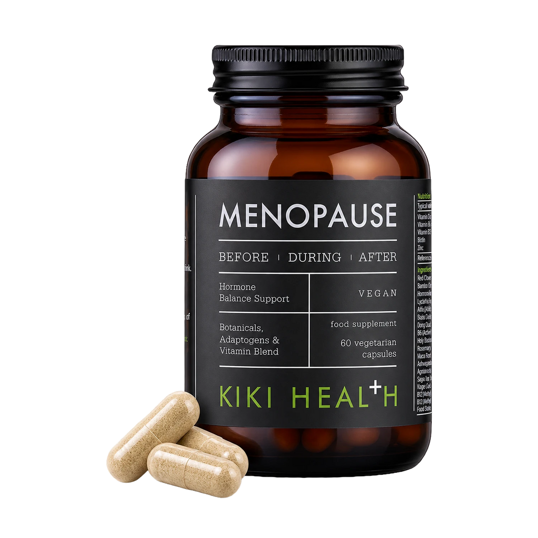 An amber supplement bottle labeled 'MENOPAUSE' by Kiki Health+ with three beige capsules placed in front on a clean white background.