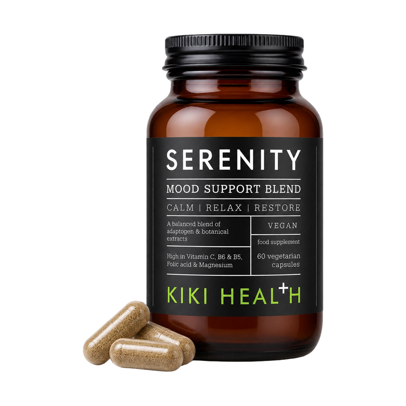 An amber glass supplement bottle labeled 'SERENITY MOOD SUPPORT BLEND' by Kiki Health, with three tan capsules placed in front on a clean white background.