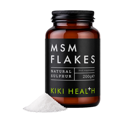 An amber glass bottle of Kiki Health MSM Flakes food supplement with a black label, shown with a small pile of white flakes in front on a white background.