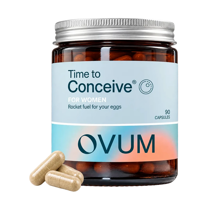 A jar of OVUM 'Time to Conceive' dietary supplement capsules on a white background, with three beige capsules placed in front of the jar.
