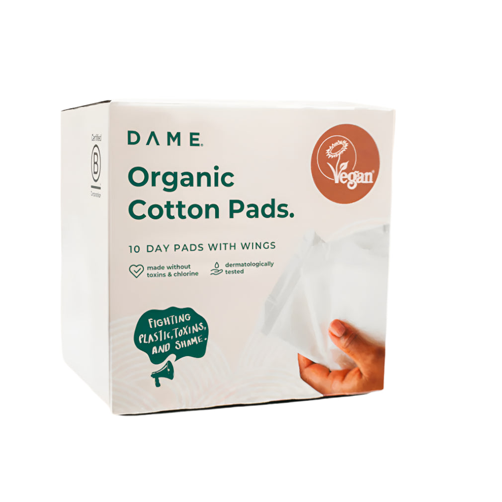 A box of Dame Organic Cotton Pads showing a white pad being held by a hand.
