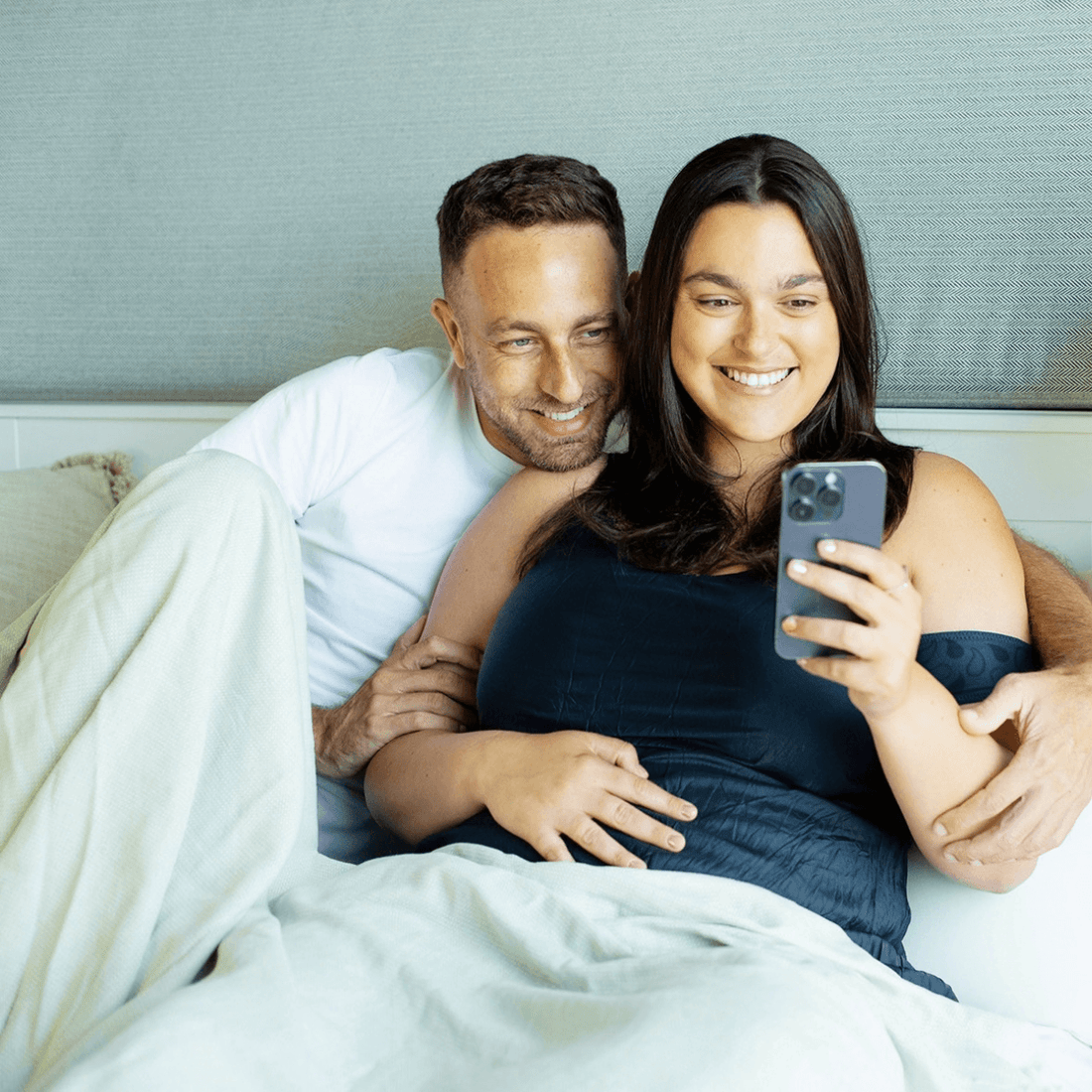 couple with woman wearing tempdrop looking at tempdrop app on smart phone