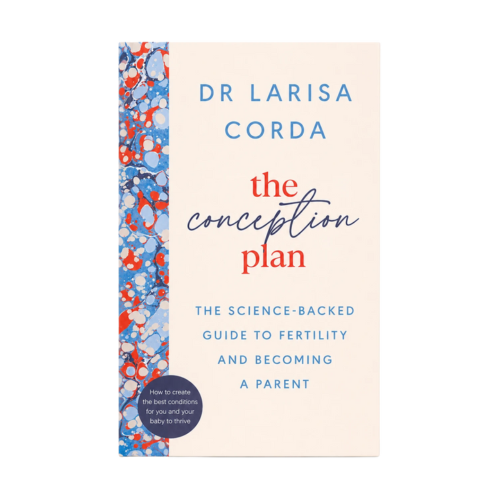 The Conception Plan book by Dr. Larisa Corda, featuring a cream-colored cover with blue and red text and a blue, red, and white patterned spine stripe.