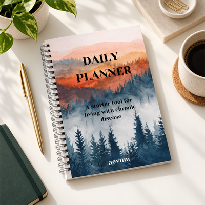 A Daily Planner titled A starter tool for living with chronic disease by aevum on a desk with coffee cup and plant.