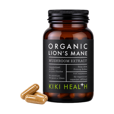 A black supplement bottle labeled 'Organic Lion's Mane Mushroom Extract' by Kiki Health, shown on a white background with three tan capsules placed in front.